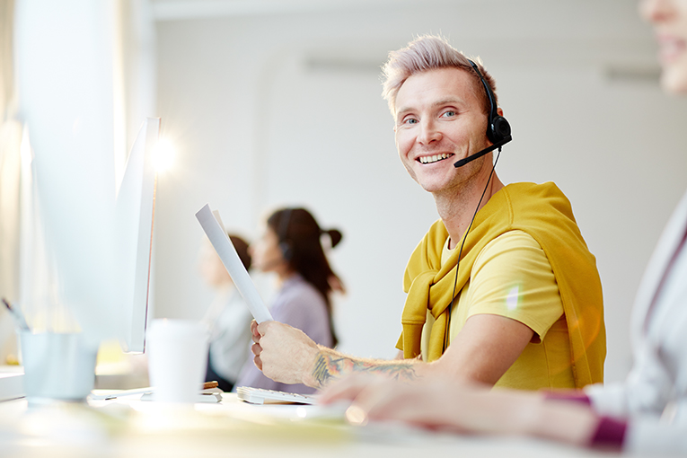 AdobeStock_193436623B Young Man at a Call Center Image